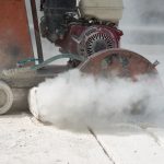Workers are cutting the asphalt on the road.